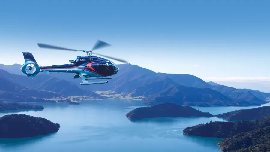 Helicopter flying above Marlborough Sounds towards Bay of Many Coves