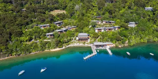 Aerial view of Bay of Many Coves resort nestled in native forest by the water in Marlborough Sounds