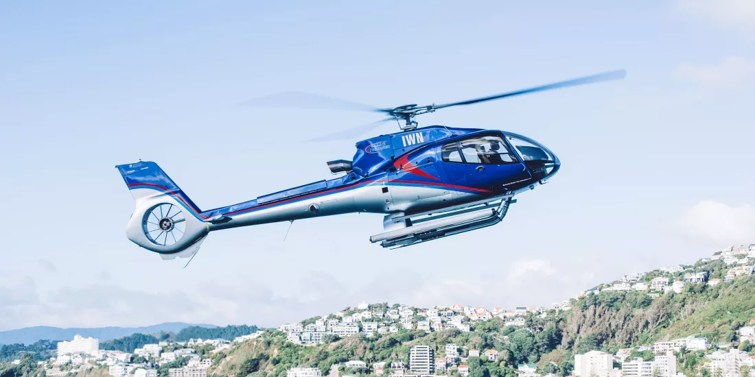 A helicopter flying over Wellington’s coastal suburbs on a clear day