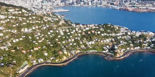Helicopter view of Wellington Harbour and coastal homes on a sunny day