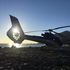 Helicopter on the rocky South Coast of New Zealand at sunset