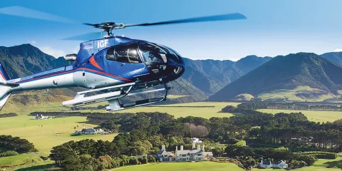 Helicopter flying over Wharekauhau Lodge with vineyard views near Wellington