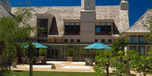 Garden terrace with blue umbrellas at Wharekauhau Country Estate on a sunny summer day