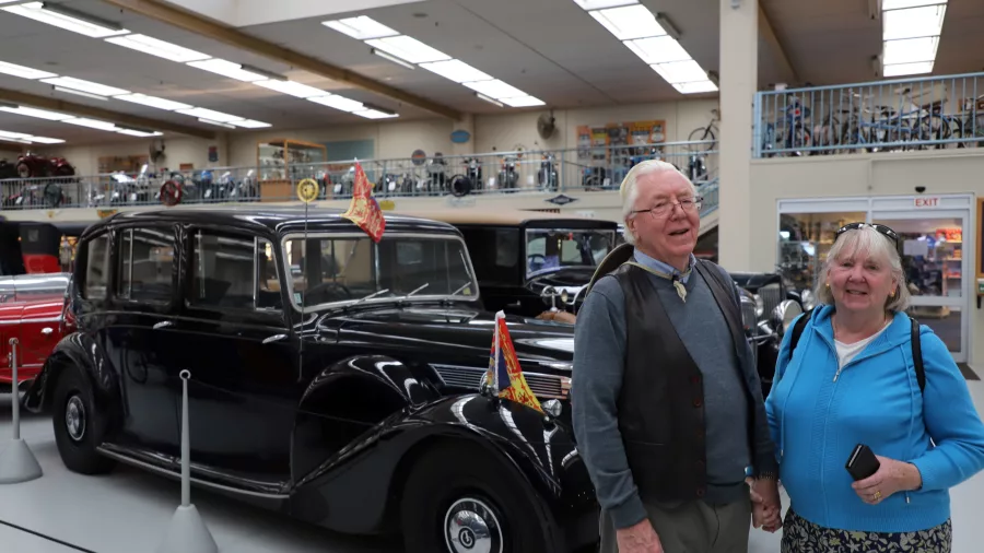 Couple posing beside a vintage car at Southward Car Museum in Paraparaumu