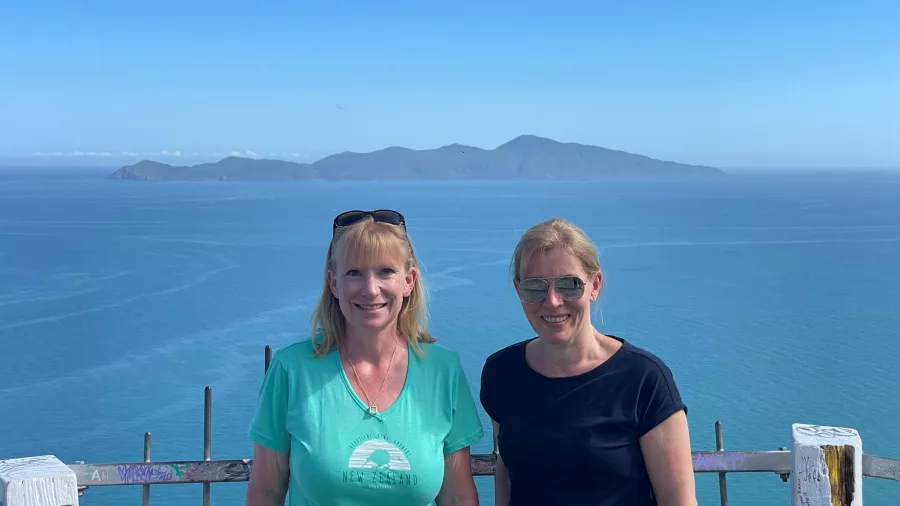 Two women at Paekākāriki Hill Lookout with clear views of Kāpiti Island and the ocean