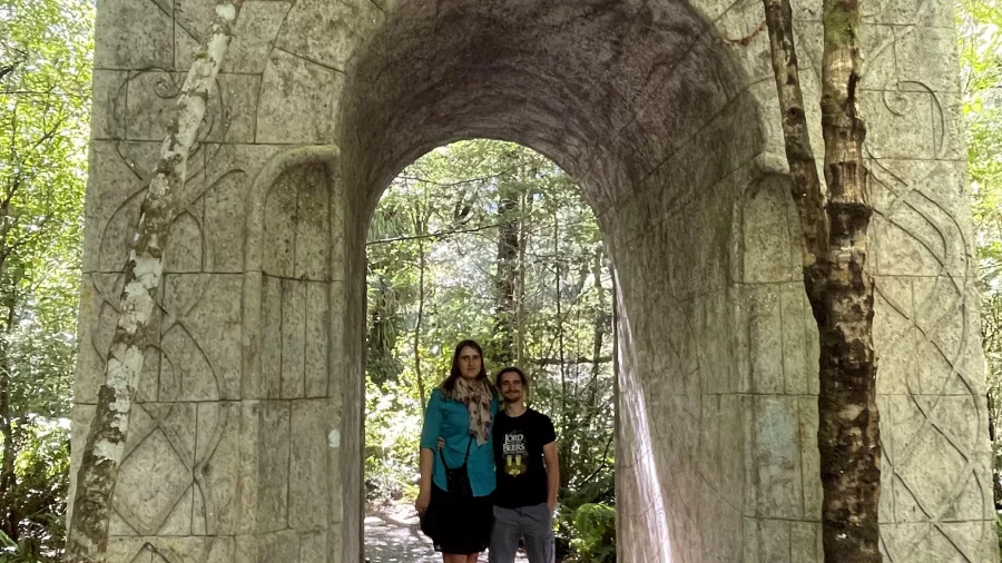 Two visitors standing beneath the Elven archway replica at Rivendell in Kaitoke Regional Park
