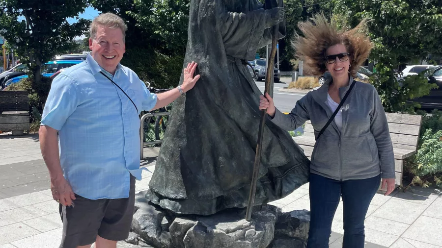 Tourists pose beside the Gandalf the Grey statue at Roxy Theatre in Miramar, Wellington, New Zealand