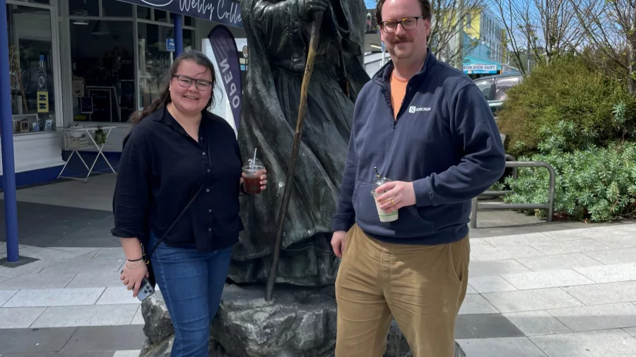 Two visitors enjoying a sunny day with the Gandalf statue outside Roxy Theatre in Miramar, Wellington, New Zealand