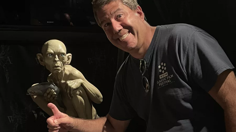 Visitor giving a thumbs up beside Gollum statue at Wētā Cave