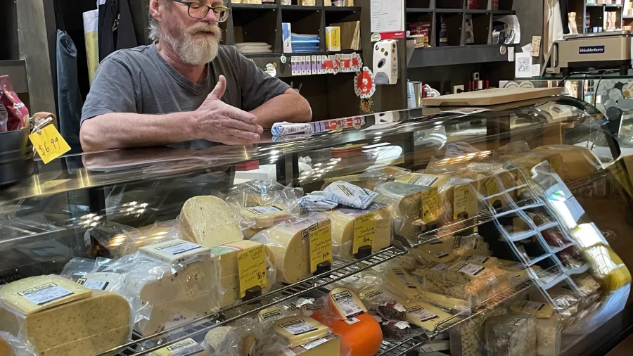 Artisan cheese display and cheesemonger at C’est Cheese in Featherston during a Kaewa Tours visit