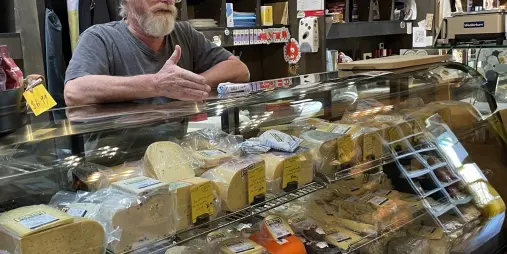 Artisan cheese display and cheesemonger at C’est Cheese in Featherston during a Kaewa Tours visit