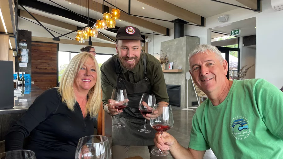 Smiling wine host with two guests at a Martinborough wine tasting
