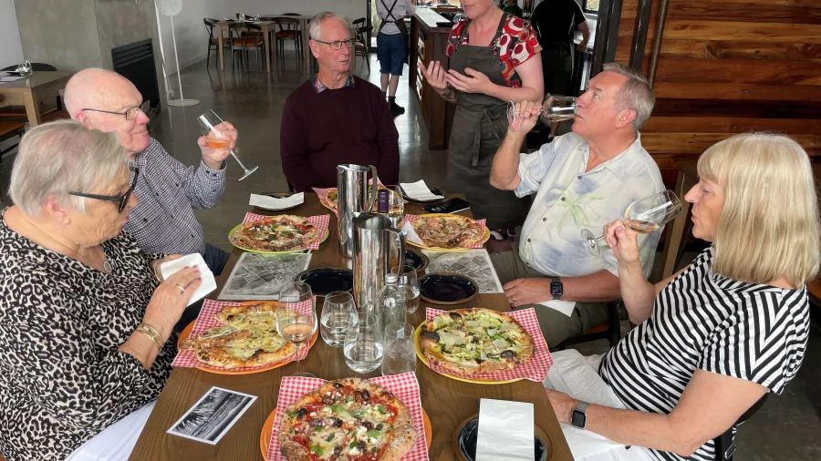 Group enjoying pizza and wine during a tasting session in Martinborough