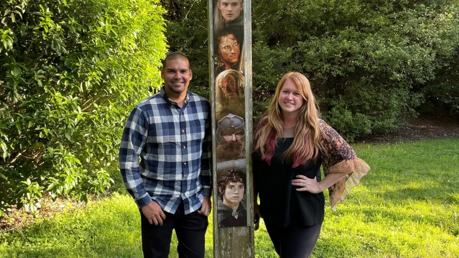Couple beside the Lord of the Rings character height check totem at Rivendell, Kaitoke Regional Park