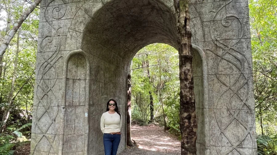 Visitor standing under the stone archway gate at Rivendell set in Kaitoke Regional Park