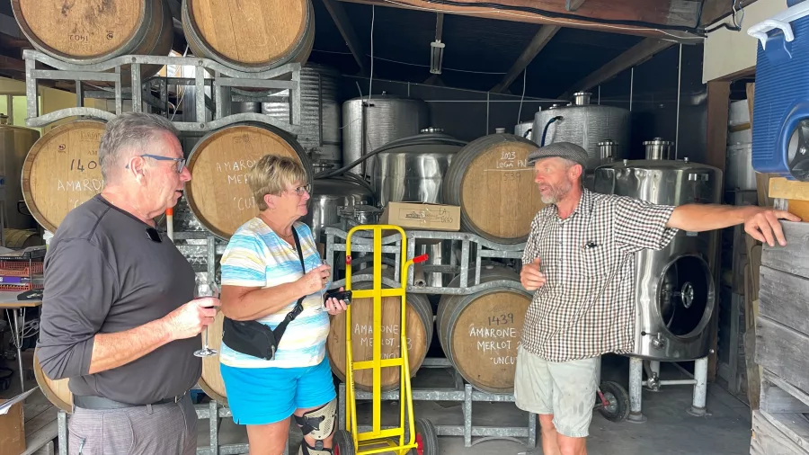 Visitors chatting with the winemaker inside the barrel room at Le Gra Vineyard in Opaki, Wairarapa