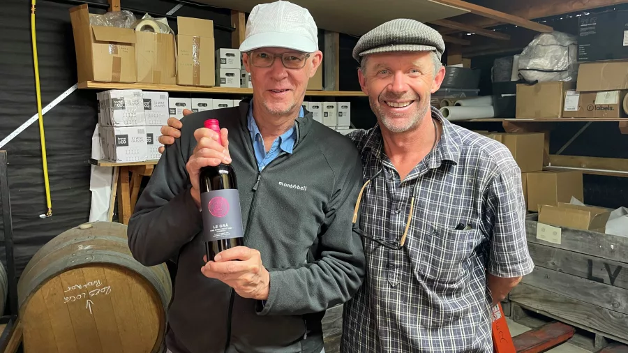 Guest holding a Le Gra wine bottle with the winemaker at Le Gra Vineyard in Opaki, Wairarapa