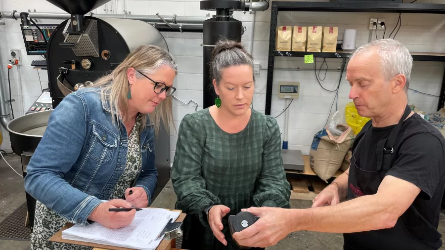 Coffee experts at The Roastery in Kāpiti examining beans and roast profiles during a workshop
