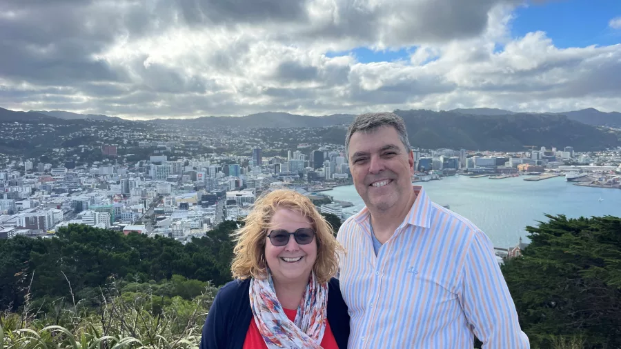Smiling couple at Mt Victoria Lookout with panoramic views of Wellington city and harbour