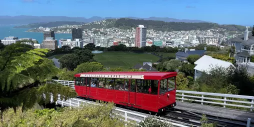 Wellington Cable Car travelling uphill with panoramic views of the city and harbour in the background