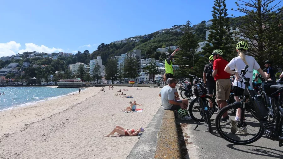 Cyclists pausing with their electric bikes along the promenade at Oriental Bay in Wellington