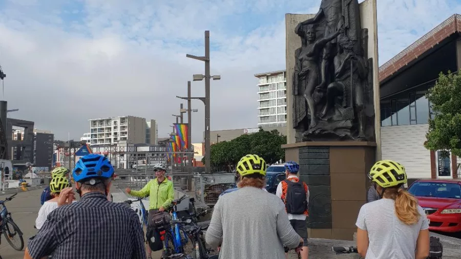Switched On Bikes group stopping at Māori statue along Wellington waterfront