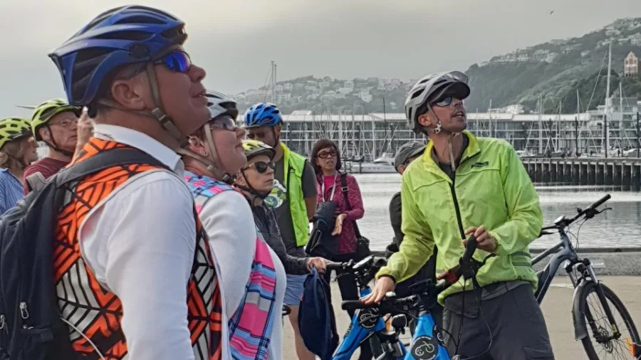 Tour group listening to a Switched On Bikes guide during orientation in Wellington waterfront