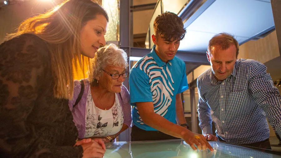 Visitors listening to a Te Papa guide during an interactive display about Māori history and culture.