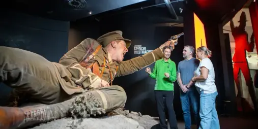 Visitors with a Te Papa guide beside the larger-than-life Lieutenant Spencer Westmacott sculpture on the Gallipoli The Scale of Our War Guided Tour