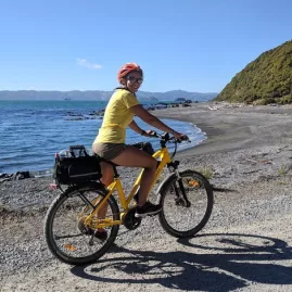 Alex Buckley cycling an e-bike along the Pencarrow coast in Wellington
