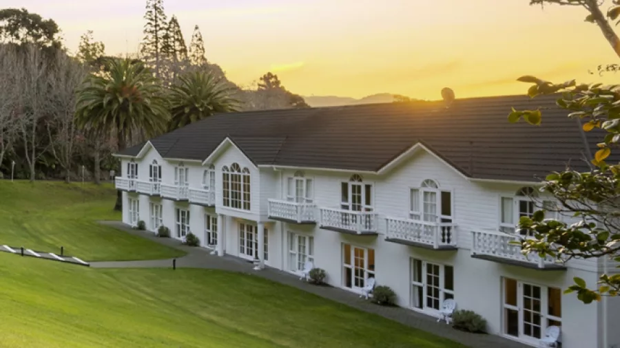 Wallaceville Country Hotel in Upper Hutt during sunset with manicured lawns and scenic hills in the background