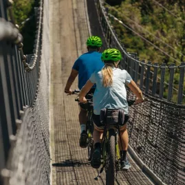 Cyclists crossing the swingbridge on the Remutaka Cycle Trail rail trail section