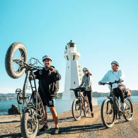 Group of cyclists near Pencarrow Lighthouse with hired bikes from Wildfinder