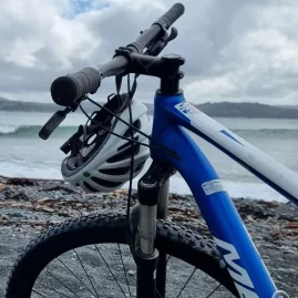 Front view of a mountain bike with helmet by the sea at Pencarrow