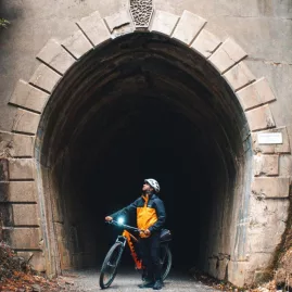 Cyclist with headlamp at entrance of Remutaka Cycle Trail tunnel