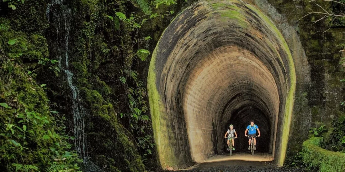 Cyclists riding through the Summit Tunnel on the Rimutaka Cycle Trail in Wellington