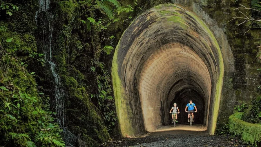 Cyclists riding through the Summit Tunnel on the Rimutaka Cycle Trail in Wellington