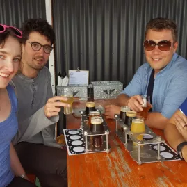 Group of friends enjoying a craft beer tasting flight at a Wellington brewery