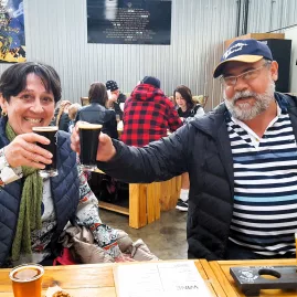 Couple toasting dark ales during a craft beer tasting in Wellington