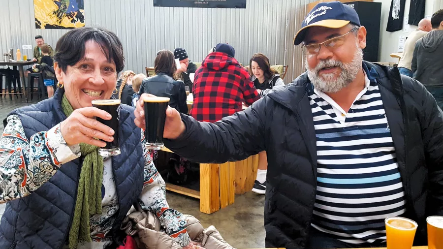 Couple toasting dark ales during a craft beer tasting in Wellington
