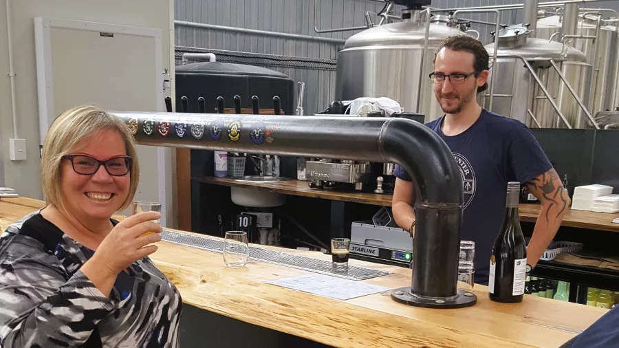 Woman smiling while tasting craft beer at a Wellington brewery