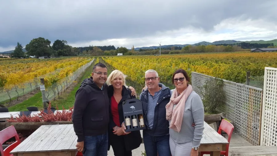 Group of four people standing in front of autumn-coloured vines at Margrain Vineyard in Martinborough