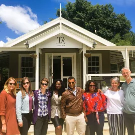 Group of travellers posing outside Te Kairanga vineyard on a Martinborough Wine Tour