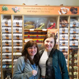Two women smiling in front of artisan chocolate display in Martinborough