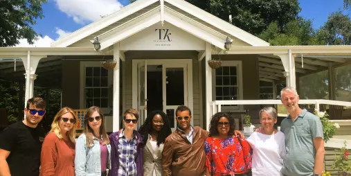 Small group of travellers posing in front of Te Kairanga Cellar Door in Martinborough