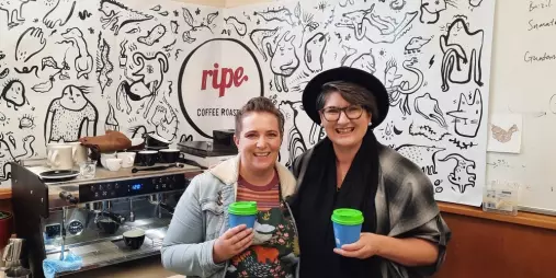 Two people smiling with coffee cups at Ripe Coffee Roasters Petone