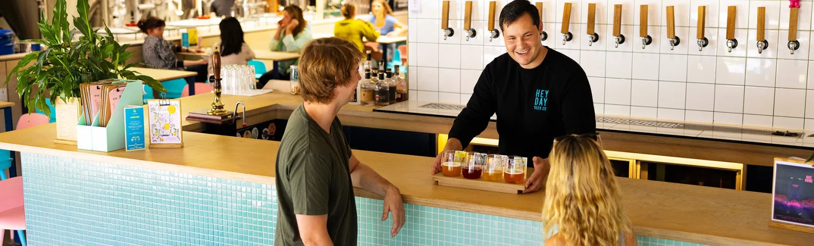 Couple receiving a flight of craft beers at Heyday Beer Co brewery in Wellington