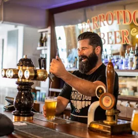 Bartender pouring craft beer at Parrotdog Brewery in Wellington with smiling customer