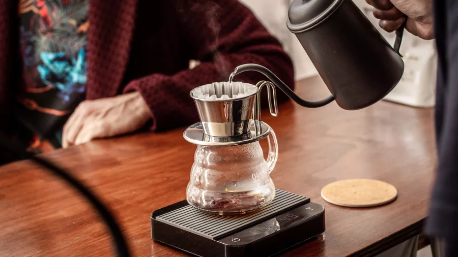 Barista pouring hot water into a pour-over dripper at Pour and Twist in Wellington
