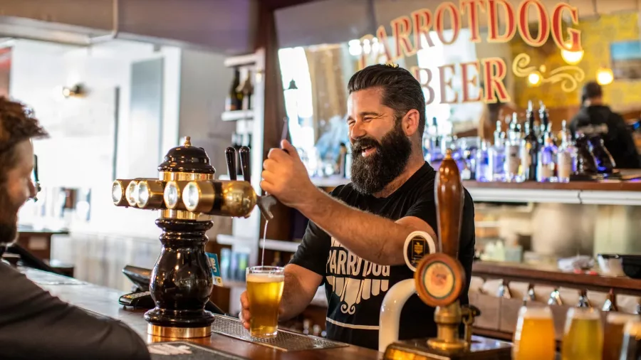 Bartender pouring craft beer at Parrotdog Brewery in Wellington with smiling customer